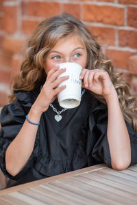 Portrait of young woman drinking coffee