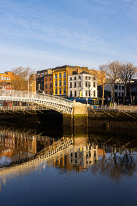 Bridge over river in city against sky