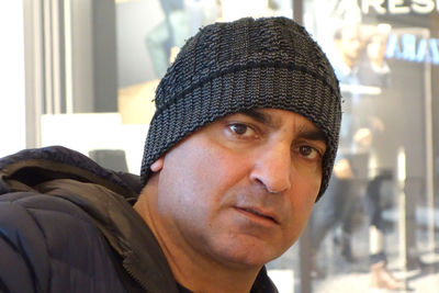 Middle adult man wearing a knitted cap, close up portrait