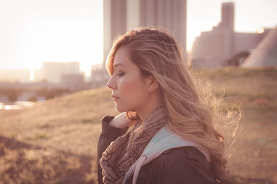 Side view of thoughtful young woman standing on field