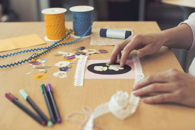 Cropped image of woman making art product on table