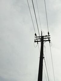 Low angle view of silhouette electricity pylon against sky