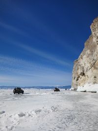 Scenic view of snowcapped mountains against blue sky on frozen lake