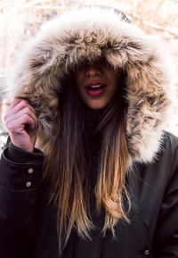 Close-up of young woman wearing fur coat