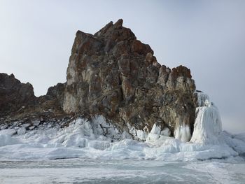 Rock formations in sea against clear sky