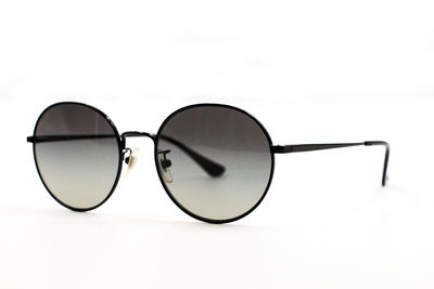 Close-up of eyeglasses on sunglasses against white background