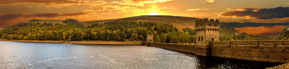 Scenic view of river against sky at sunset