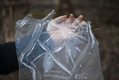 Close-up of hand holding ice outdoors