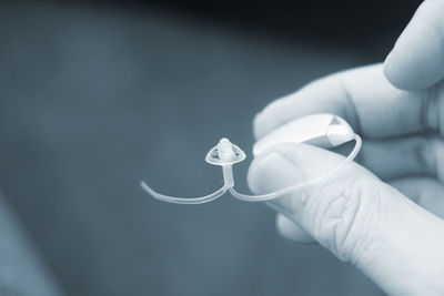 Close-up of hand holding hearing aid