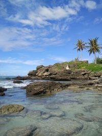 Rock formation on beach against sky