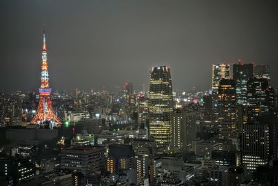 Illuminated cityscape against sky at night