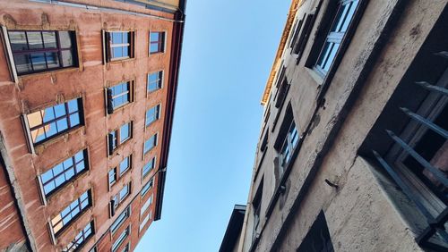 Low angle view of buildings against clear blue sky