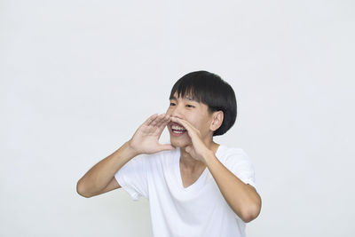 Portrait of boy standing against white background