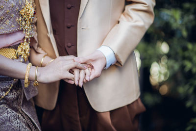 Midsection of couple holding hands
