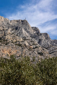 Low angle view of rocky mountain against sky