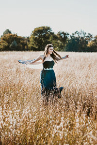 Woman with arms raised on field