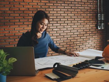 Mid adult woman using laptop on table