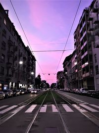 View of city street and buildings at dusk