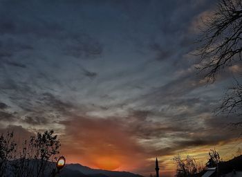 Low angle view of silhouette trees against dramatic sky