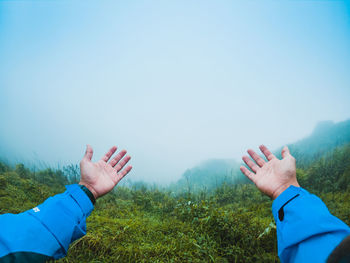 Midsection of man with hands against sky