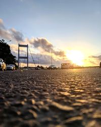 Surface level of road against sky during sunset