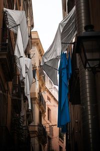 Low angle view of clothes drying outdoors of buildings