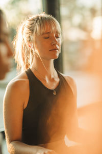 Young woman meditating with eyes closed at retreat center