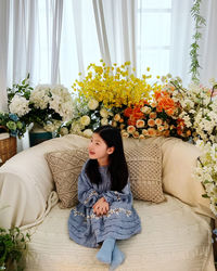 Portrait of woman sitting on sofa at home