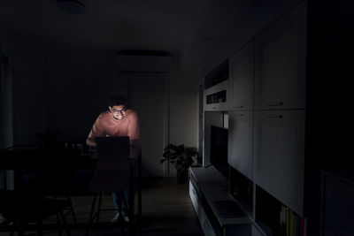 Happy young man using laptop in living room