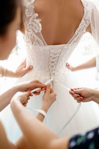 Midsection of bride holding wedding dress