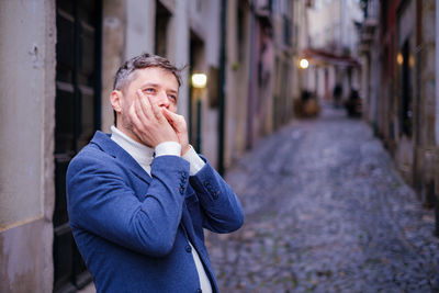 Portrait of young woman standing against wall
