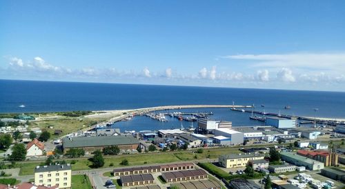 High angle view of town by sea against sky