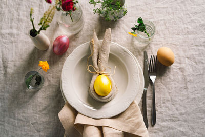 Happy easter. stylish easter eggs on a napkin with spring flowers on white wooden background