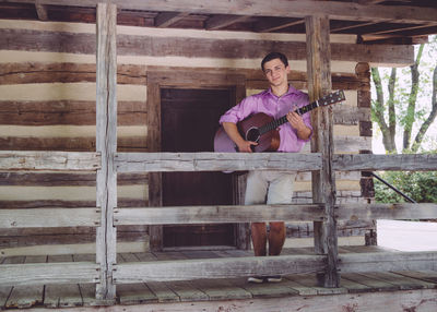 Portrait of young woman playing guitar