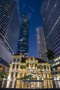 Low angle view of illuminated buildings in city at night