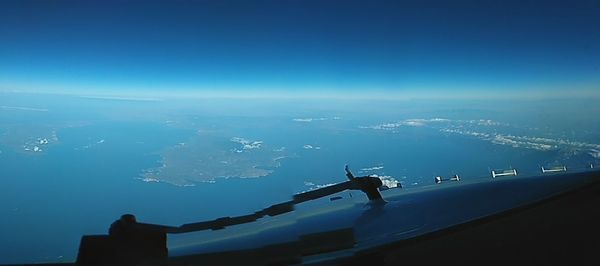 Aerial view of sea and cityscape against sky