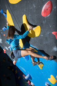 Athletic girl climbing on an indoor climbing wall