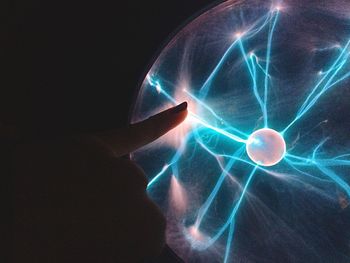 Close-up of illuminated lighting equipment against black background