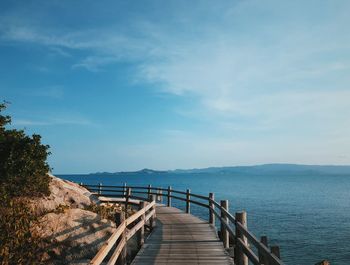 Empty pier over sea against sky