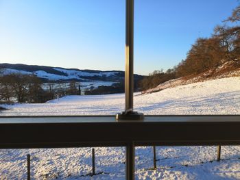 Snow covered field against clear sky