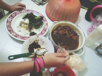 High angle view of hand holding food on table