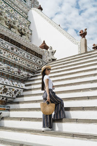 Low angle view of woman standing on staircase against building