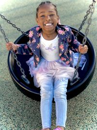 Beautiful brown girl smiling gleefully at the playground. 