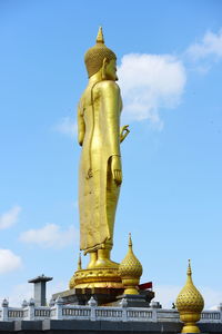 Low angle view of statue against building against sky