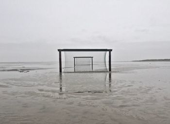 Lifeguard hut on beach against sky