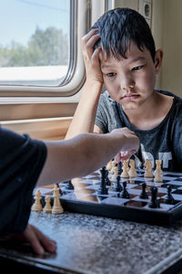 Young boys playing chess in the train