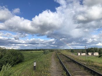 Railroad tracks on field against sky
