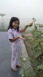 Cute girl standing against plants