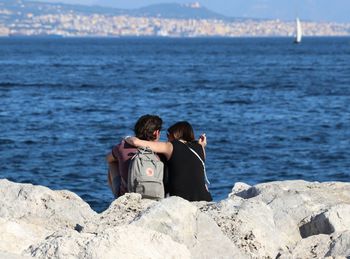 Rear view of couple sitting on beach