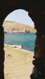 Scenic view of sea seen through arch